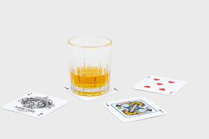 Glass of whiskey on playing mat coasters